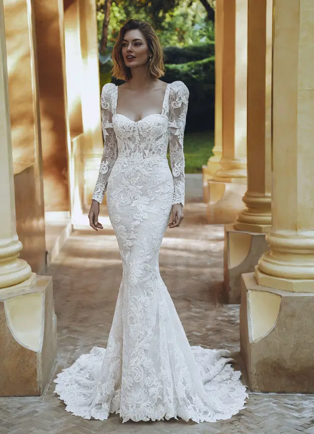 URVASHI by Enzoani: Mermaid silhouette, sweetheart neckline, long sleeves, lace